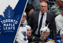 Craig Berube strategizing during an NHL game, showcasing his intense coaching style and dedication to hockey excellence.