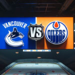 How to Watch Canucks vs Oilers Game 4: TV, Streaming & More | May 14, 2024 Vancouver Canucks and Edmonton Oilers logos on an NHL scoreboard with the word vs. between the logos
