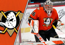 Anaheim Ducks goalie John Gibson skates towards the net, making a save during an NHL game.