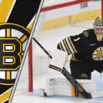 Jeremy Swayman in Boston Bruins uniform standing in front of a net with a determined expression.