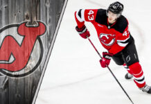 Luke Hughes of the New Jersey Devils skates with the puck during an NHL game