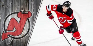Luke Hughes of the New Jersey Devils skates with the puck during an NHL game