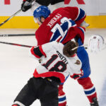 Arber Xhekaj checks Tim Stutzle during an NHL preseason game.