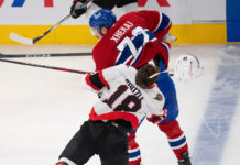 Arber Xhekaj checks Tim Stutzle during an NHL preseason game.