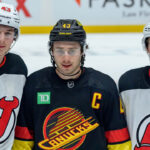Quinn Hughes Rumors: Blockbuster Trade Proposal Sends Canucks Captain to Devils Quinn Hughes in a Vancouver Canucks jersey with his brothers in New Jersey Devils uniform
