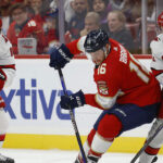 Puck drops between Carolina Hurricanes and Florida Panthers players during intense NHL playoff action for Game 4 of the Eastern Conference Final.
