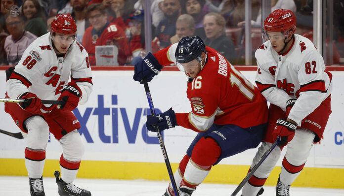 Puck drops between Carolina Hurricanes and Florida Panthers players during intense NHL playoff action for Game 4 of the Eastern Conference Final.