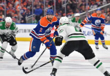 Dallas Stars and Edmonton Oilers players battling for the puck during the NHL Western Conference Finals Game 5.