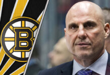Rick Tocchet behind the bench during an NHL game, rumored to be a top coaching candidate for the Boston Bruins