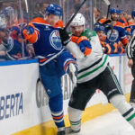 Edmonton Oilers and Dallas Stars logos clashing with a hockey puck, symbolizing their Game 2 playoff matchup on May 23 2025.