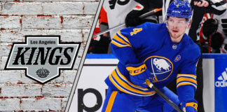 An action shot of Buffalo Sabres defenseman Bowen Byram skating with the puck, with a subtle Los Angeles Kings logo in the background.