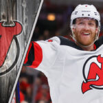 ew Jersey Devils defenseman Dougie Hamilton skates with the puck during an NHL game, with NHL trade rumors swirling around his future with the team.