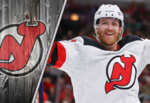 ew Jersey Devils defenseman Dougie Hamilton skates with the puck during an NHL game, with NHL trade rumors swirling around his future with the team.