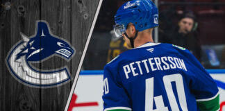 Vancouver Canucks forward Elias Pettersson skates with the puck during an NHL game, looking focused.