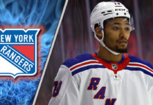 New York Rangers defenseman K'Andre Miller skates with the puck during an NHL game, with NHL trade rumors swirling.