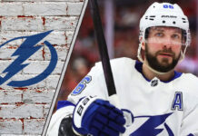An intense, focused shot of Nikita Kucherov in his Tampa Bay Lightning jersey, stick in hand, looking ready to make a play on the ice.