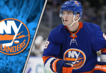 A focused shot of New York Islanders defenseman Noah Dobson skating with the puck during an NHL game.