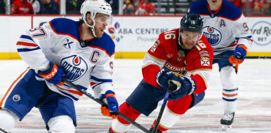 A thrilling face-off between a Florida Panthers and Edmonton Oilers player during Game 1 of the 2025 Stanley Cup Final.