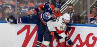 The Edmonton Oilers and Florida Panthers face off in a thrilling Stanley Cup Final Game 4 matchup, with players battling for the puck in front of the net.