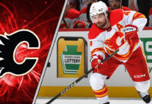 Calgary Flames defenseman Rasmus Andersson looks on during an NHL game, with NHL trade rumors circulating about his future with the team.