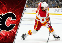 Rasmus Andersson in a Calgary Flames jersey skates with the puck during an NHL game.