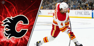 Rasmus Andersson in a Calgary Flames jersey skates with the puck during an NHL game.