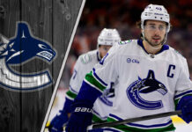 Vancouver Canucks defenseman Quinn Hughes skates with the puck, quarterbacking the power play during an NHL game.