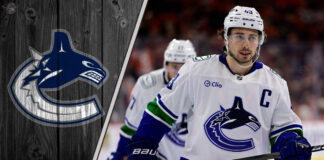 Vancouver Canucks defenseman Quinn Hughes skates with the puck, quarterbacking the power play during an NHL game.