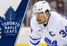 Auston Matthews getting ready for a face-off with the Leafs logo to the left