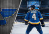 Bowen Byram in a St. Louis Blues jersey at center ice of the Enterprise Center