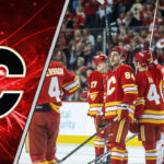 The Calgary Flames team skating on the ice in their red jerseys during a pre-season game.