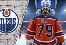 Close-up of goalie Carter Hart looking focused, with an Edmonton Oilers logo faded in the background, representing the latest NHL trade rumors.