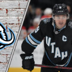 A focused Clayton Keller of the Utah Mammoth skates with the puck during an NHL game, poised for a breakout season.