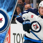 Winnipeg Jets defenseman Dylan Samberg skating during a game, highlighting the recent news of his contract arbitration filing.