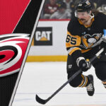 Erik Karlsson skating in his Pittsburgh Penguins jersey, amidst swirling NHL trade rumors involving the Carolina Hurricanes.