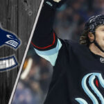 Jared McCann to Vancouver? Inside the Rumors of a Canucks Reunion Jared McCann skates in his Seattle Kraken uniform, with the Vancouver Canucks logo faded into the background, illustrating recent NHL trade rumors.