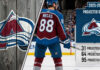 Martin Necas of the Colorado Avalanche stands at center ice, wearing his #88 jersey. A graphic overlay details his 2025-26 projected stats: 31 goals, 64 assists, and 95 points.