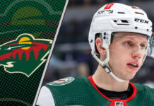 Minnesota Wild center Marco Rossi skates with the puck during an NHL game, looking focused amid ongoing contract negotiations.