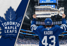 Nazem Kadri in a Toronto Maple Leafs jersey, holding the Stanley Cup at center ice.