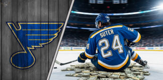 Pius Suter in St. Louis Blues jersey, sitting on money at center ice.