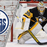Pittsburgh Penguins goalie Tristan Jarry in his gear, looking on during a game, amidst recent NHL trade rumors linking him to the Edmonton Oilers.