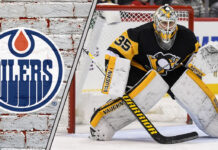 Pittsburgh Penguins goalie Tristan Jarry in his gear, looking on during a game, amidst recent NHL trade rumors linking him to the Edmonton Oilers.