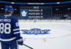 William Nylander is at center ice, looking at the Leafs logo, with a graphic overlay of his projected 2025-26 stats