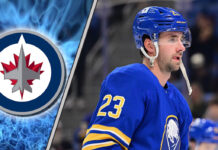 An image of Mattias Samuelsson in his Buffalo Sabres jersey, looking focused during a game, with the Winnipeg Jets logo in the background.