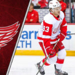 Alex DeBrincat skating in his red Detroit Red Wings jersey, a key player for 2025-26 fantasy hockey point projections.
