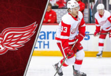 Alex DeBrincat skating in his red Detroit Red Wings jersey, a key player for 2025-26 fantasy hockey point projections.