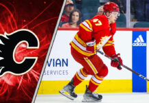 Calgary Flames forward Connor Zary skating with the puck during an NHL game, looking determined