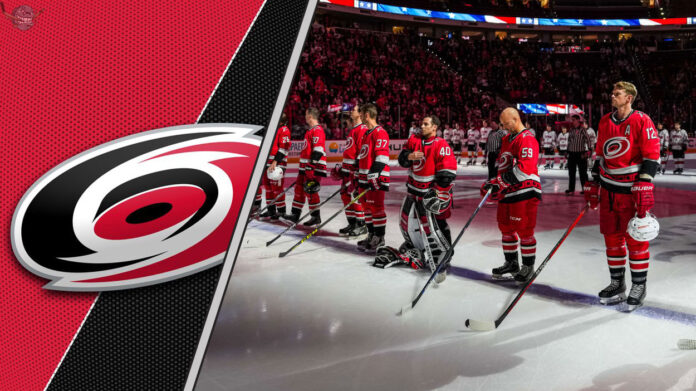 carolina-hurricanes-team-celebration-2025 The Carolina Hurricanes team standing on the ice, preparing for a game, with the crowd cheering in the background.