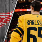 Is Erik Karlsson the High-Stakes Gamble That Makes the Detroit Red Wings a Contender? Pittsburgh Penguins forward Erik Karlsson standing on the ice with the Detroit Red Wings logo to the left as NHL trade rumors swirl around him