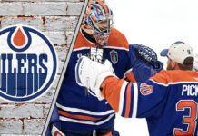 Edmonton Oilers goalies celebrating a win, with the team's logo in the background.
